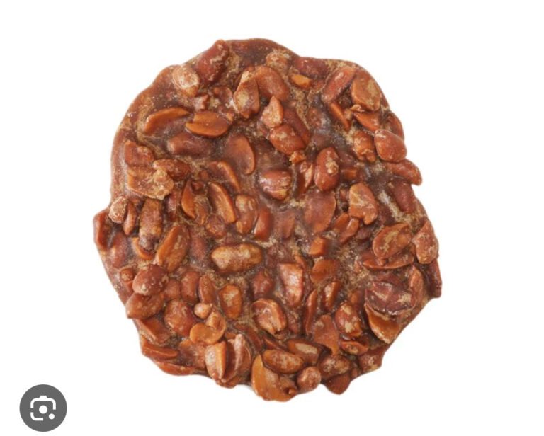 A round cookie with nuts on top of it.
