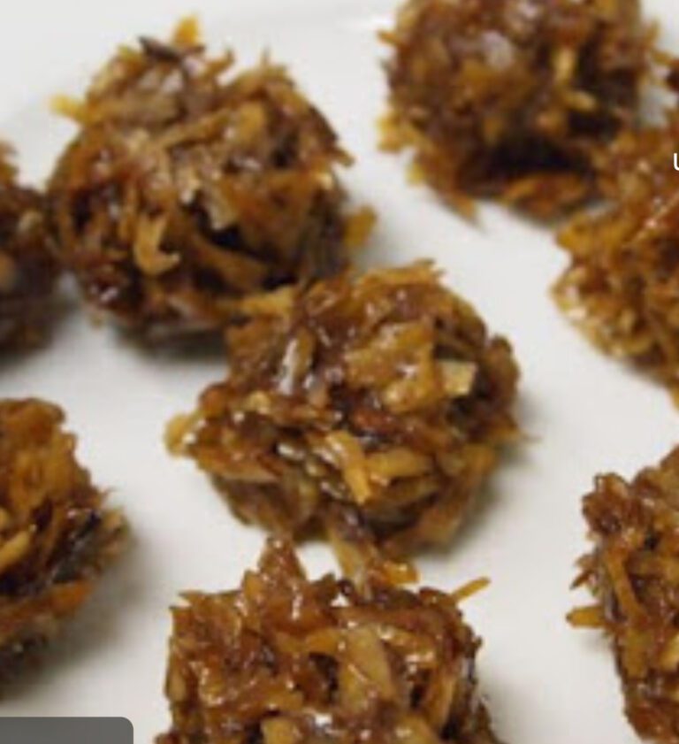 A white plate topped with lots of coconut covered cookies.