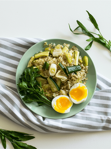 A plate of food with eggs and greens on the side.