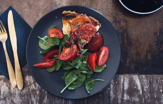 A plate of food with tomatoes and spinach.