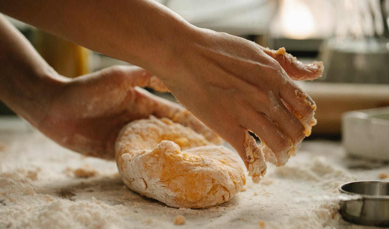 A person is making bread on the table.