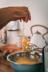 A person is pouring liquid into an egg.